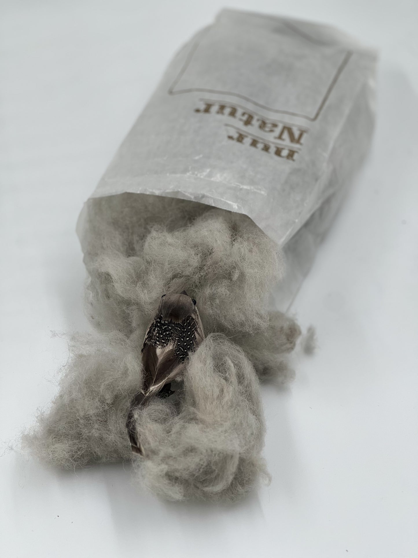 Vogel sammelt Nistmaterial aus Alpakawolle